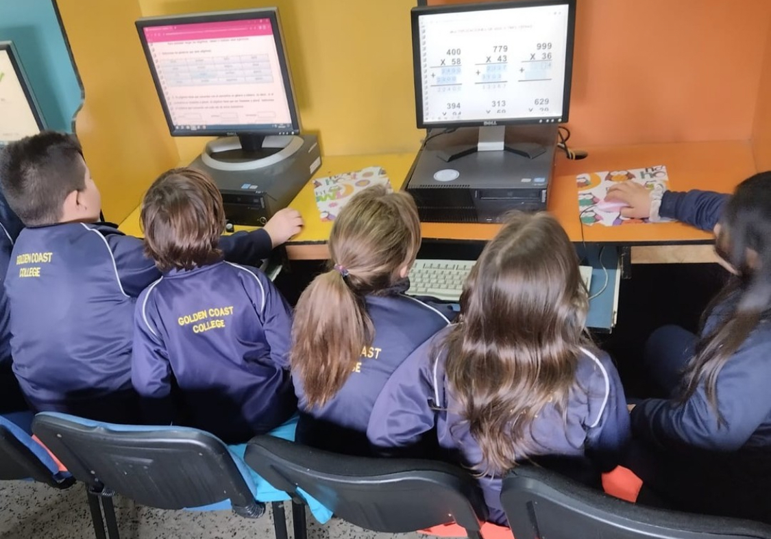 Estudiantes trabajando con computadoras en el aula de informática