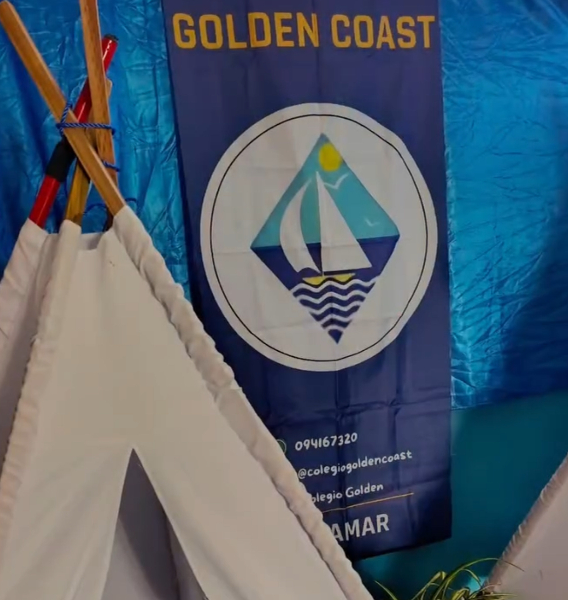 Rincón de campamento con carpa y cartel institucional del Colegio Golden