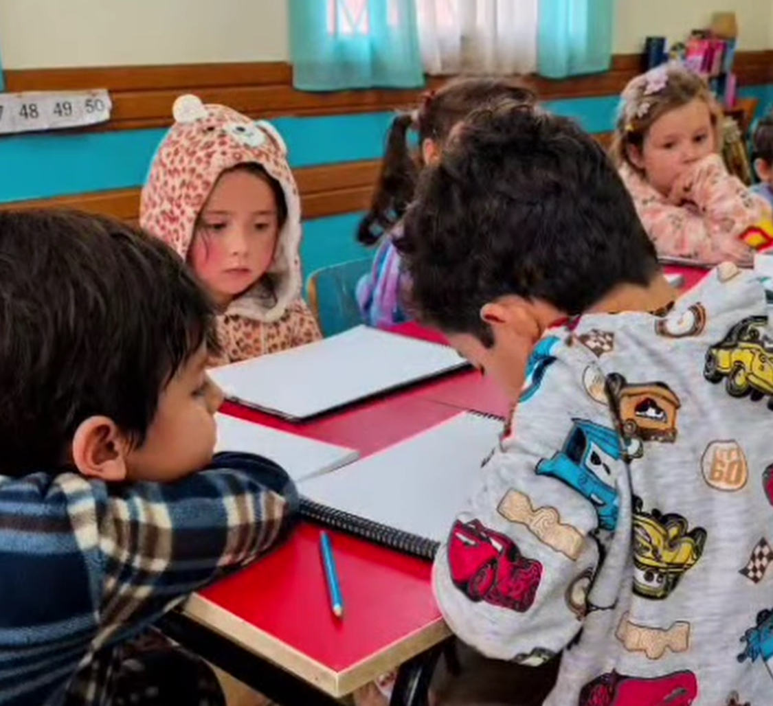 Niños realizando una actividad de escritura en el aula